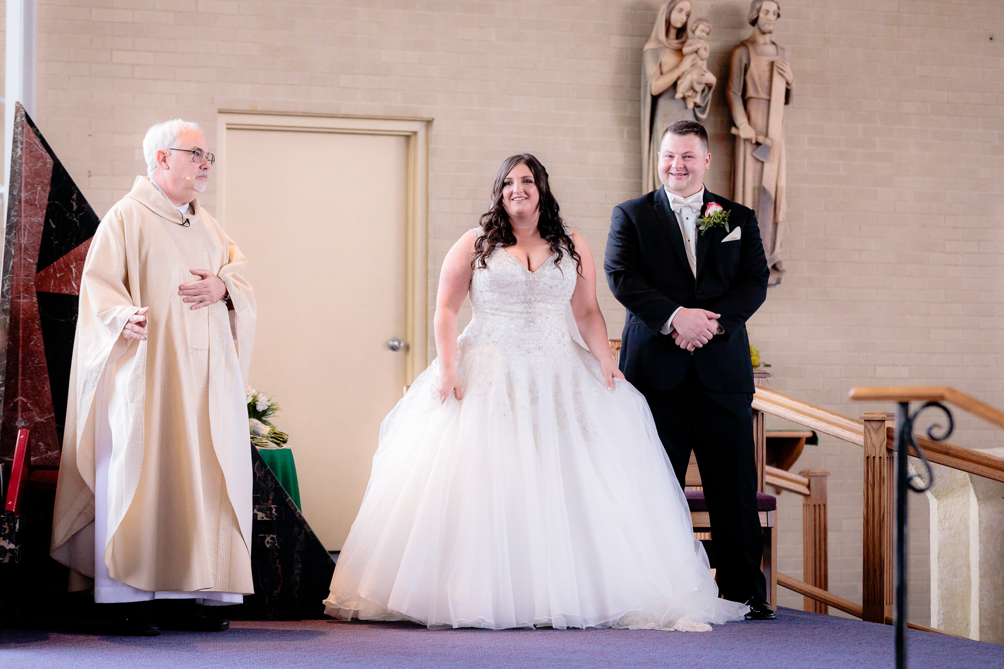 Bride & groom stand on the altar during a St. Malachy wedding ceremony