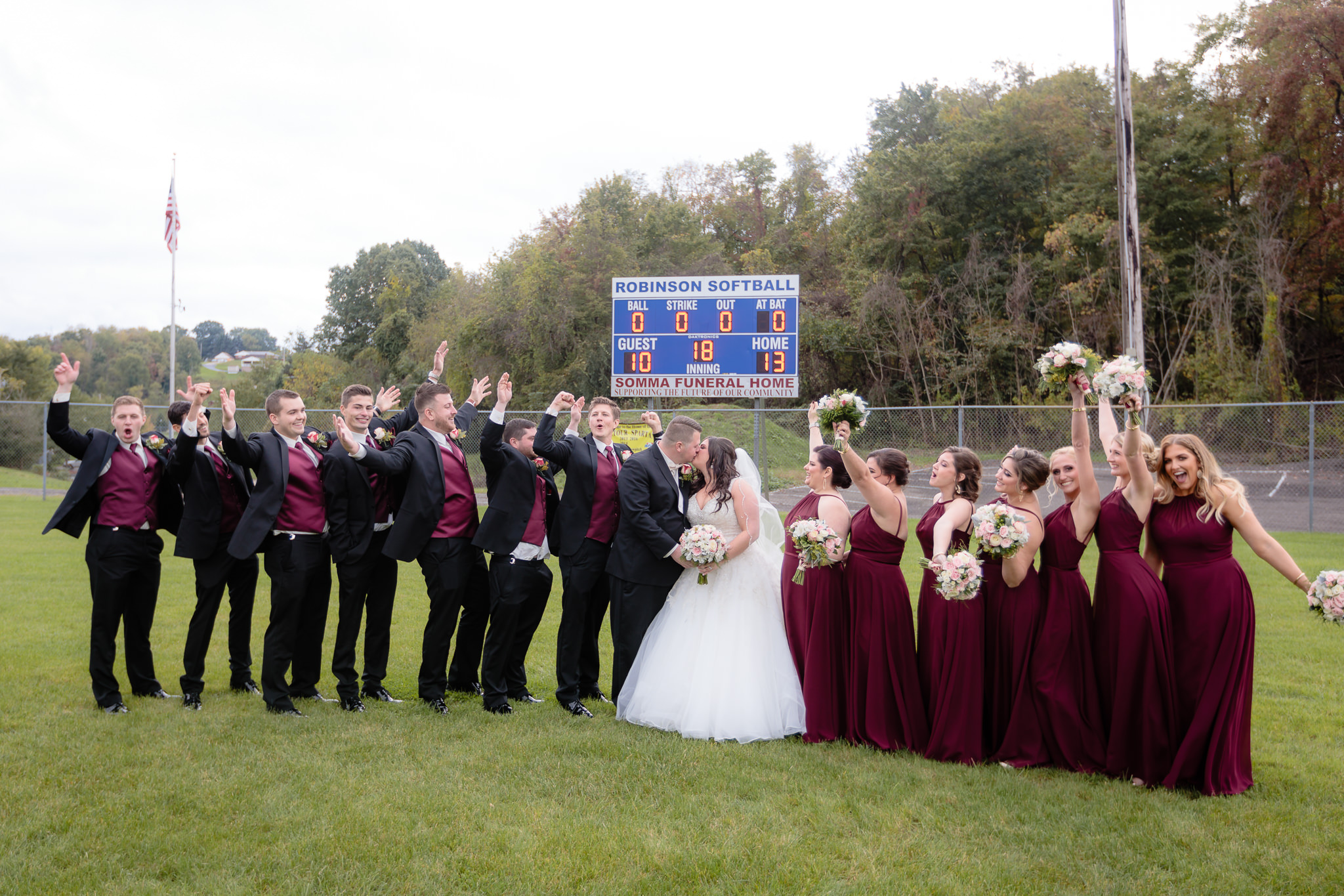 Bridal party cheers in the outfield of the Robinson Township Girls Softball field