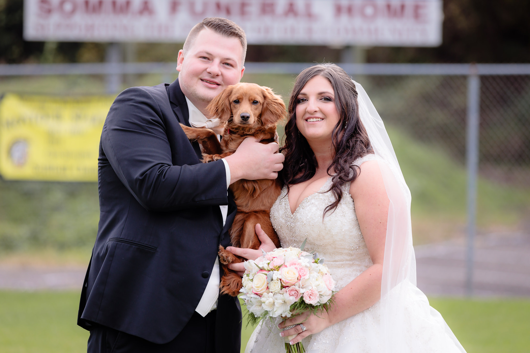 Bride and groom with their dog at the Robinson Township Girls Softball field