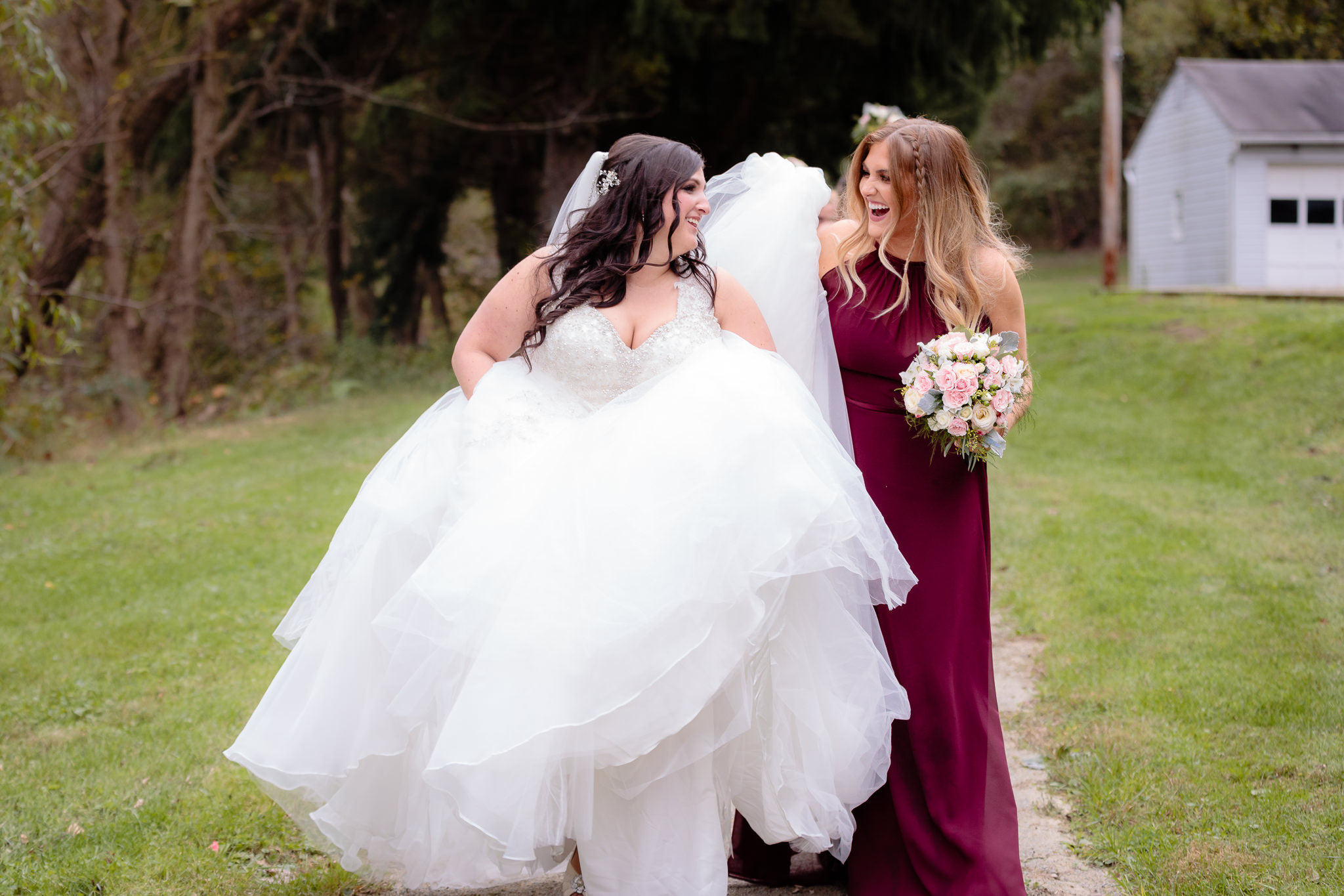 Bridesmaid helps the bride walk with her dress at Olson Park in Moon Township