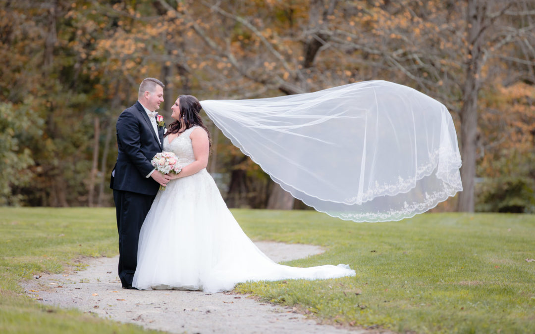 Bride's cathedral veil blows in the wind during portraits at Olson Park