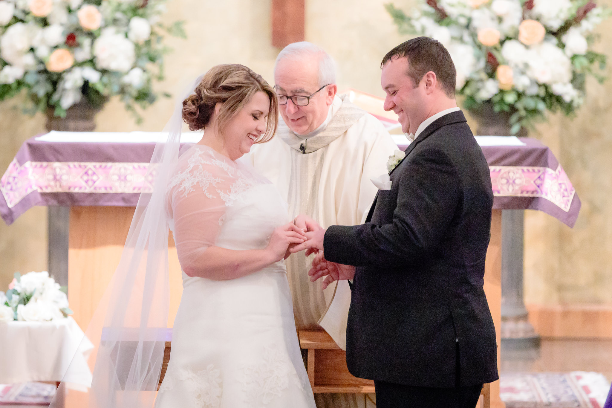 Bride puts groom's ring on his finger during a wedding ceremony at Mother of Sorrows Church