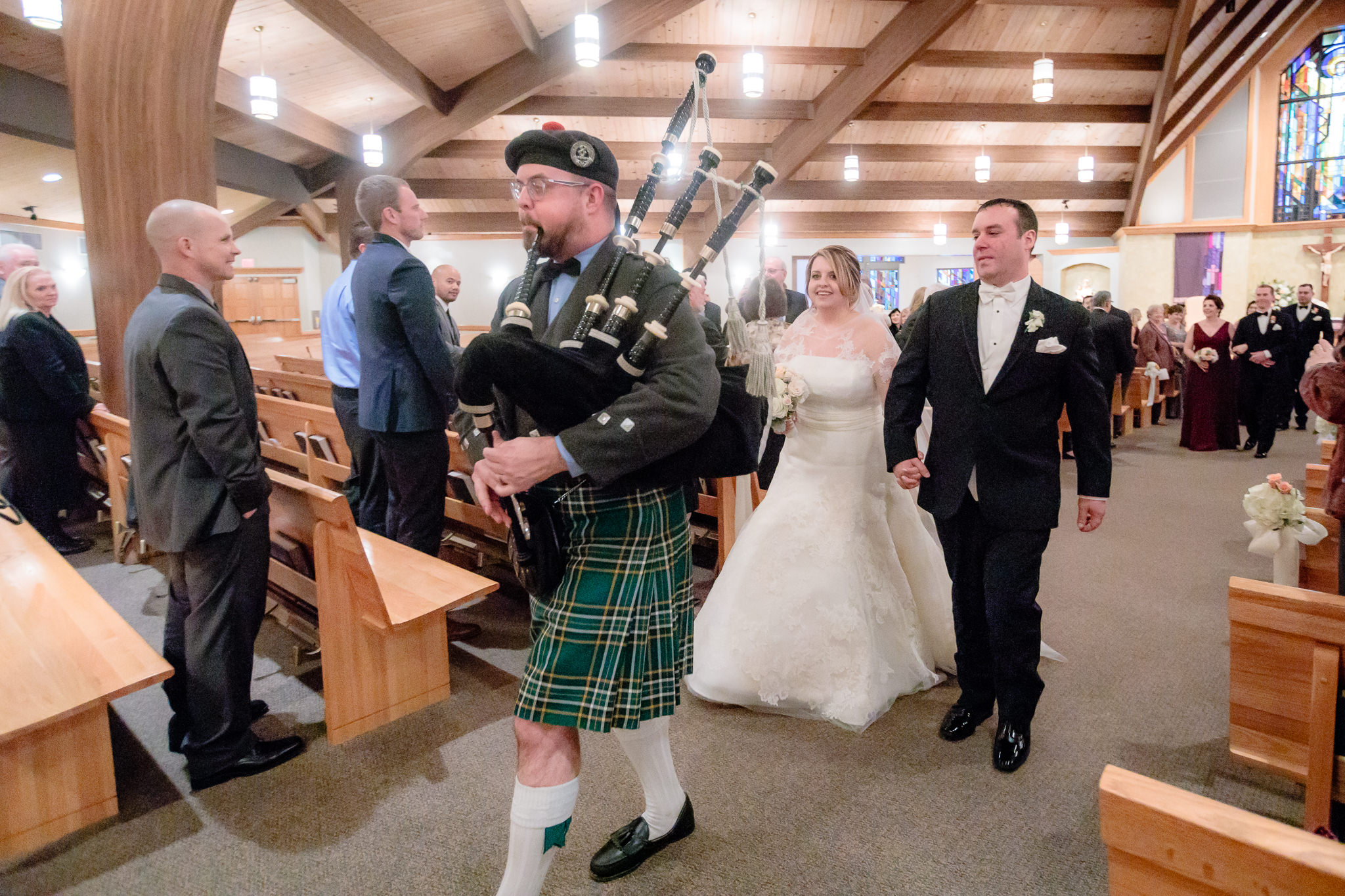 Bagpipe player leads newlyweds out of their ceremony at Mother of Sorrows Church in Murrysville