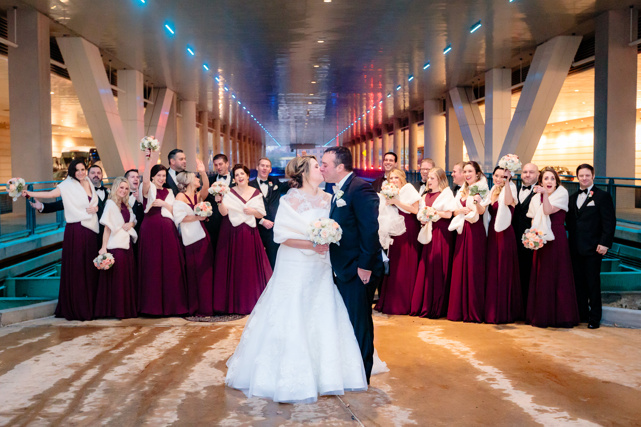 Newlyweds kiss as their bridal party cheers at the David L. Lawrence Convention Center in Pittsburgh