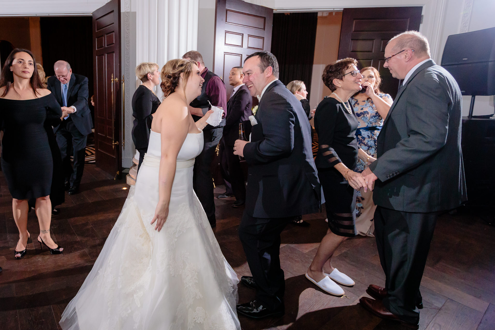 Newlyweds dance with guests at their Hotel Monaco wedding reception