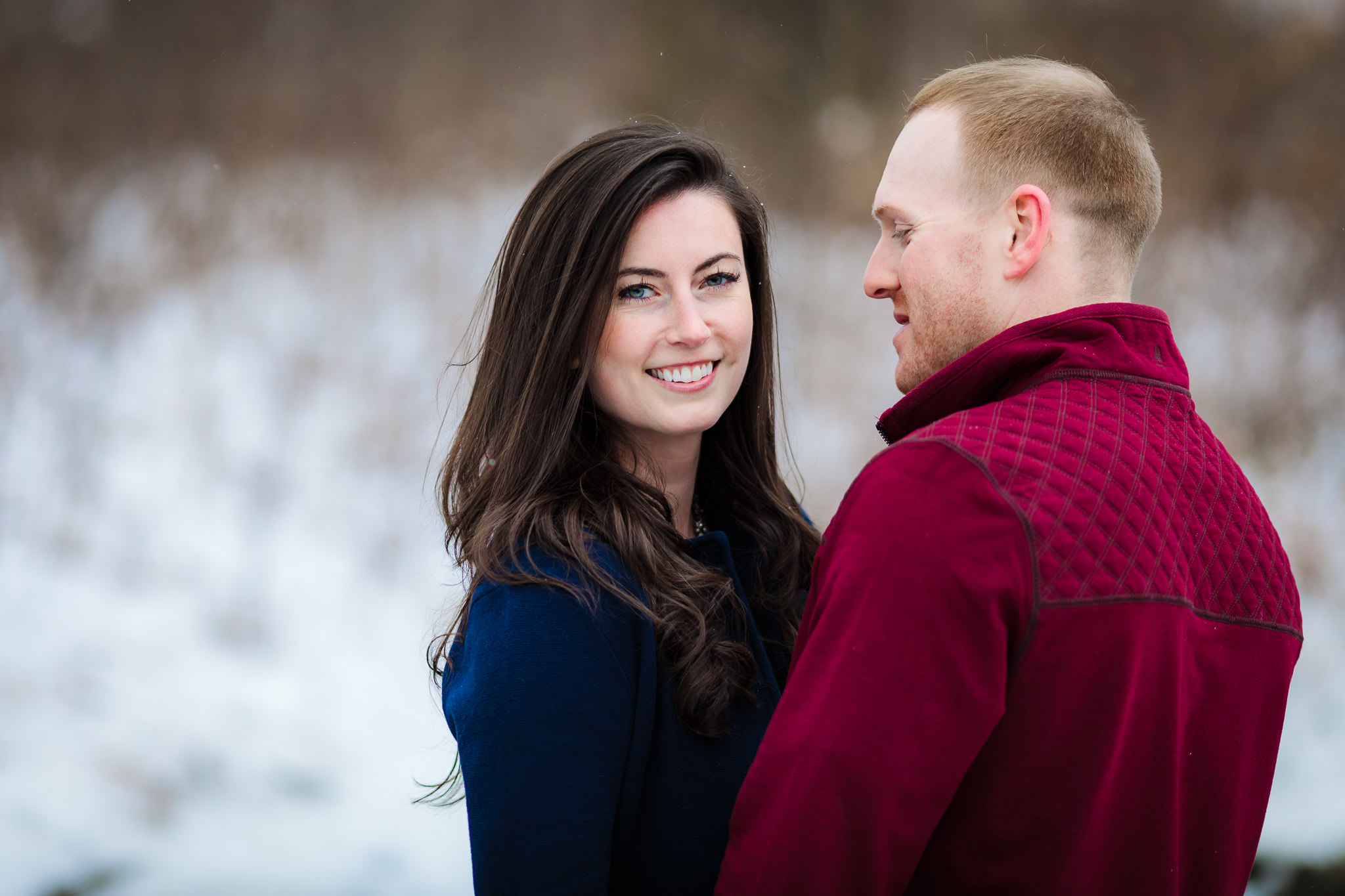 Future bride smiles during snowy engagement session at Point State Park in Pittsburgh, PA