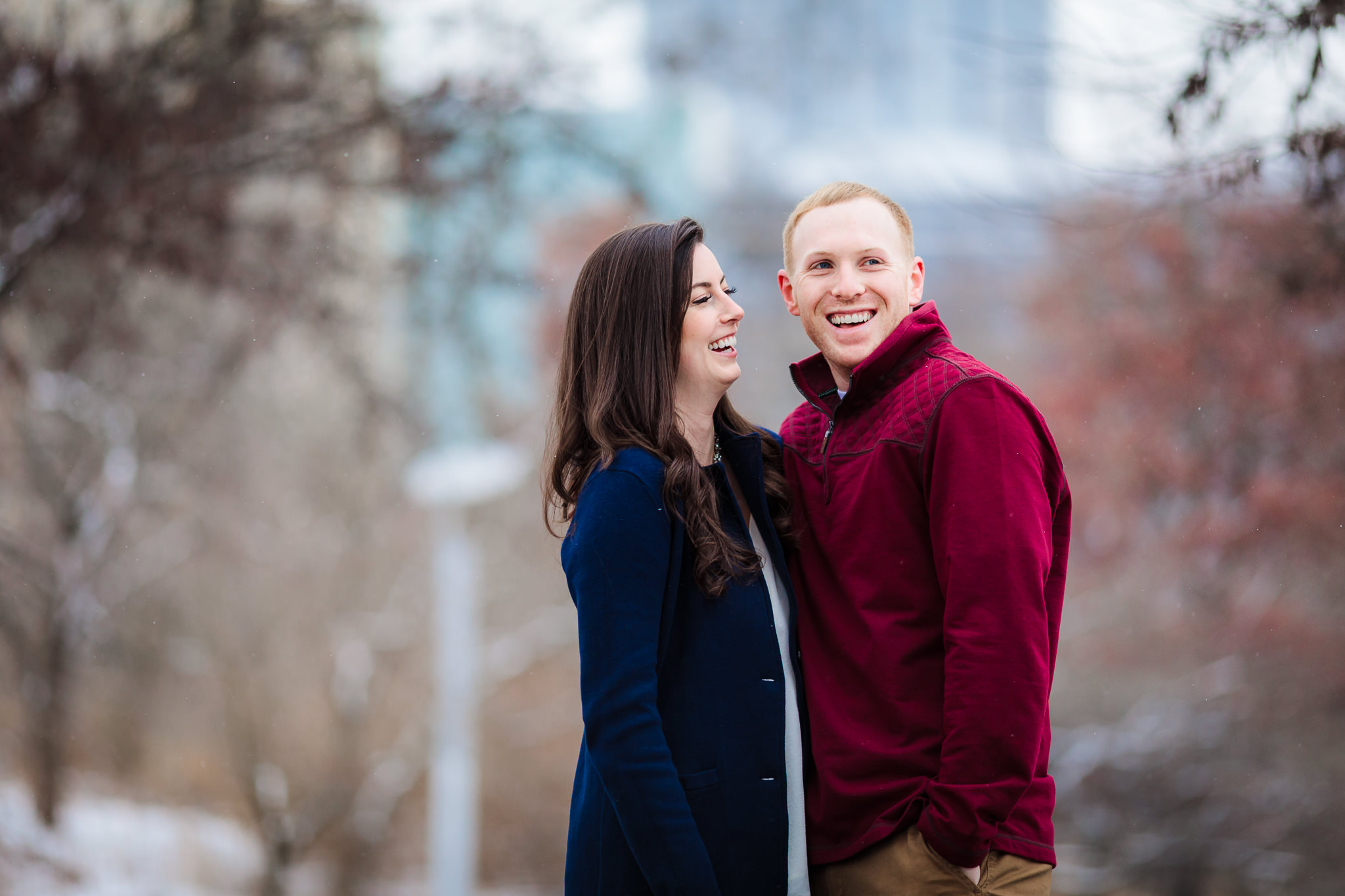 Couple laughs during winter engagement session in Point State Park in Pittsburgh, PA