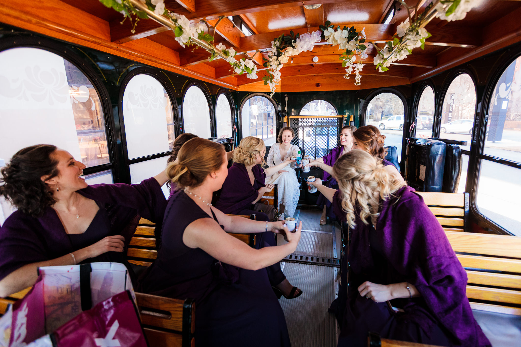 Bridesmaids toast the bride inside a Molly's Trolleys ride to her Heinz Chapel wedding in Pittsburgh, PA