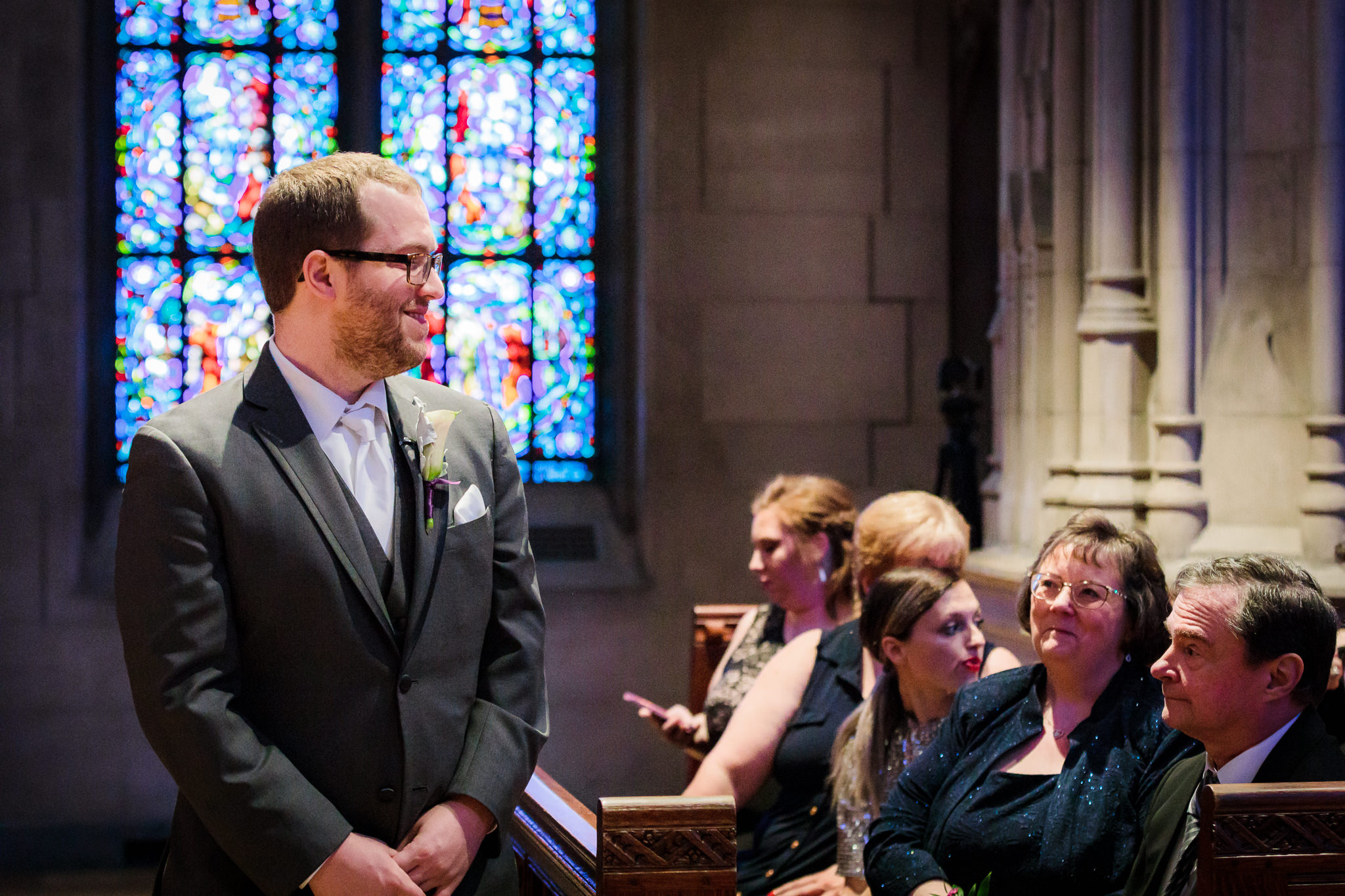 Groom smiles as his bride walks down the aisle at Heinz Chapel in Pittsburgh