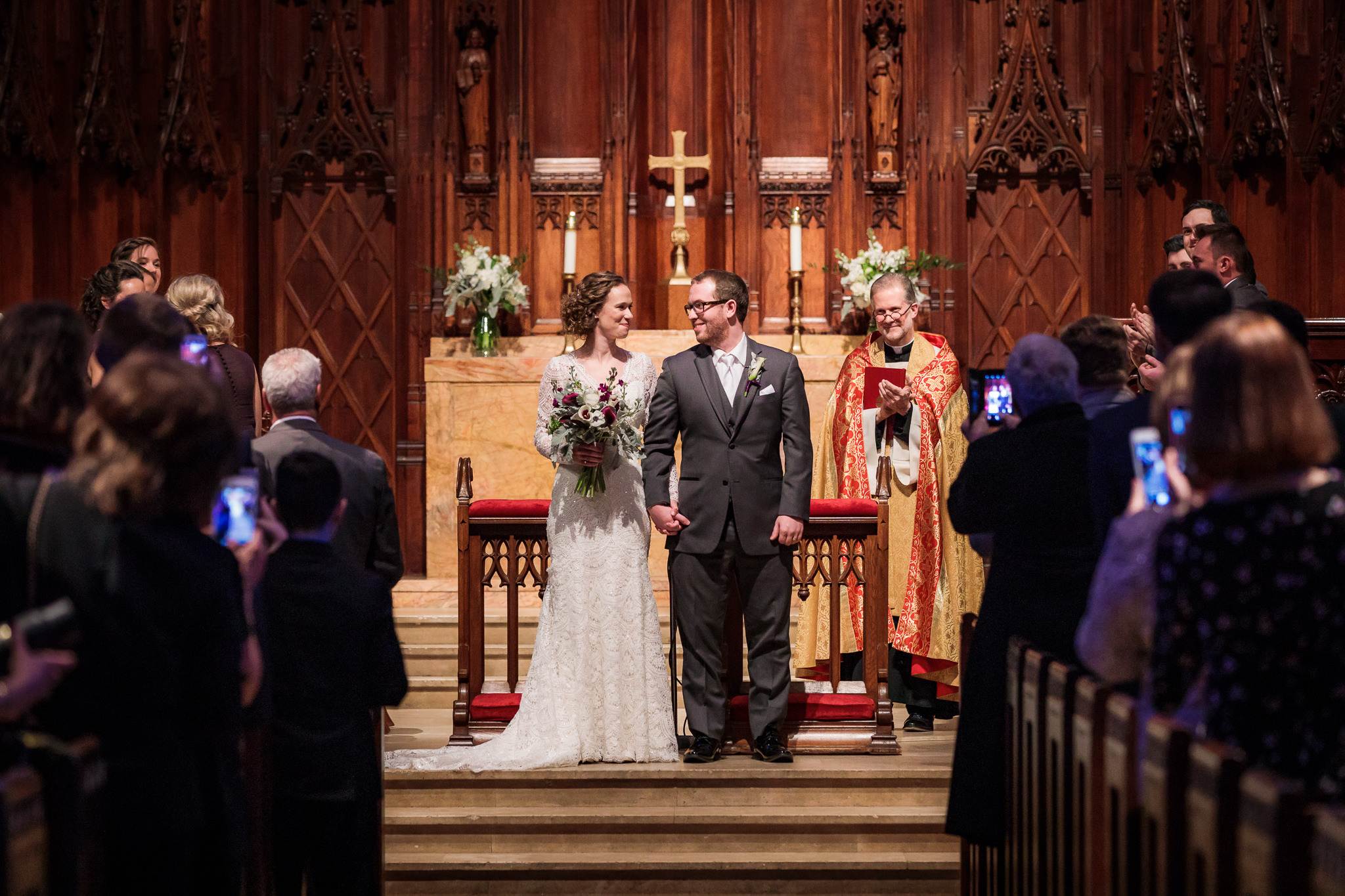 Newlyweds smile at each other as they're announced as Mr. & Mrs. at Heinz Chapel