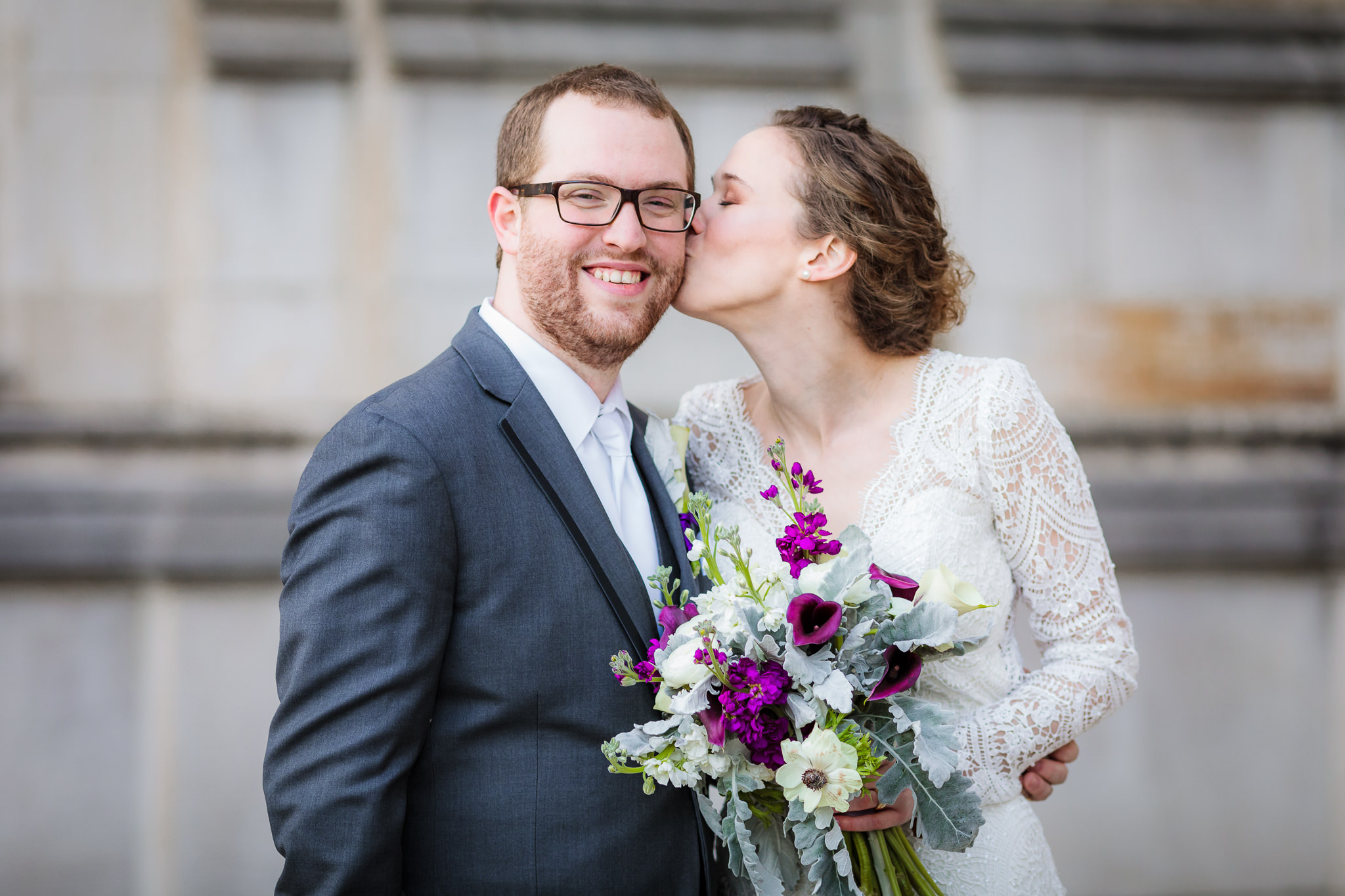 Bride kisses her groom on the cheek during portraits at the Cathedral of Learning