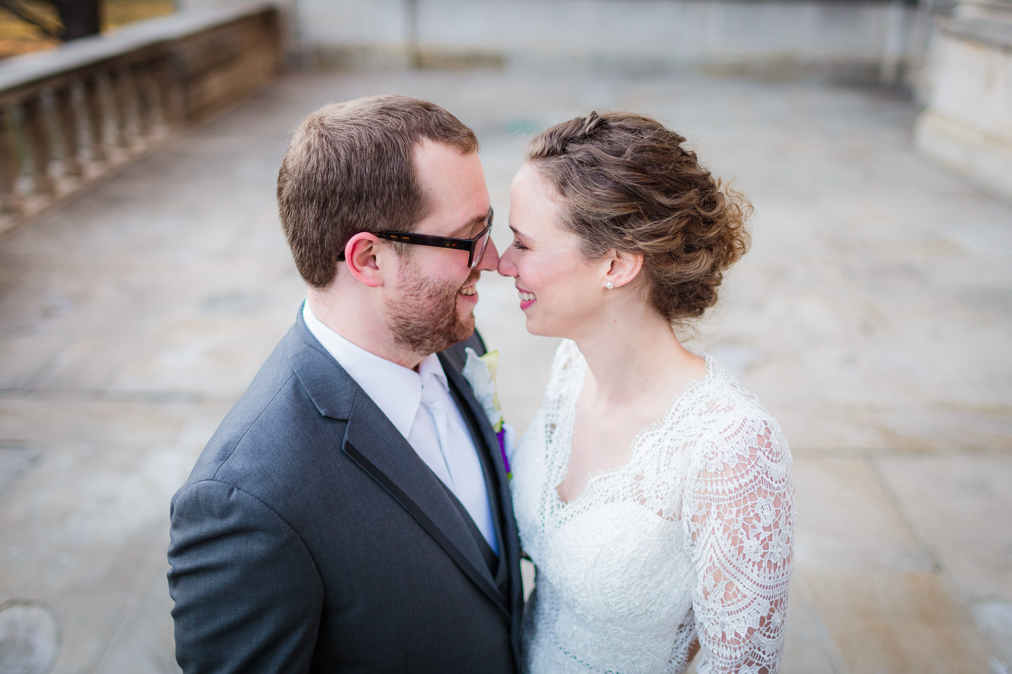 Newlyweds give eskimo kisses on the patio of the Cathedral of Learning