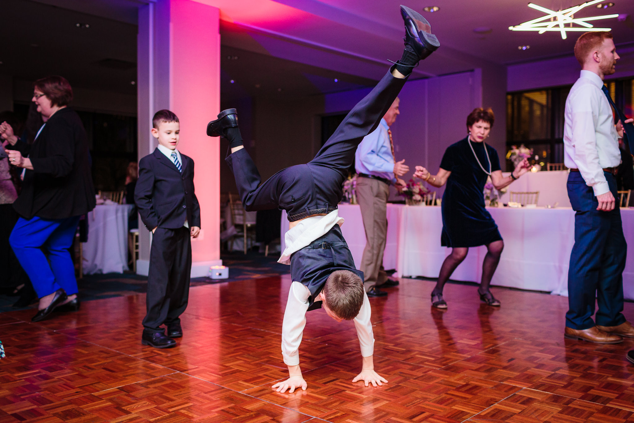 Boy does a handstand on the dance floor at a DoubleTree Pittsburgh Downtown wedding reception