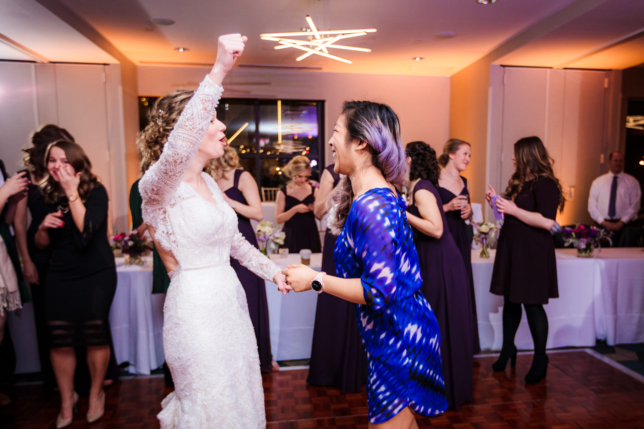 Bride cheers with the girl who caught the bouquet