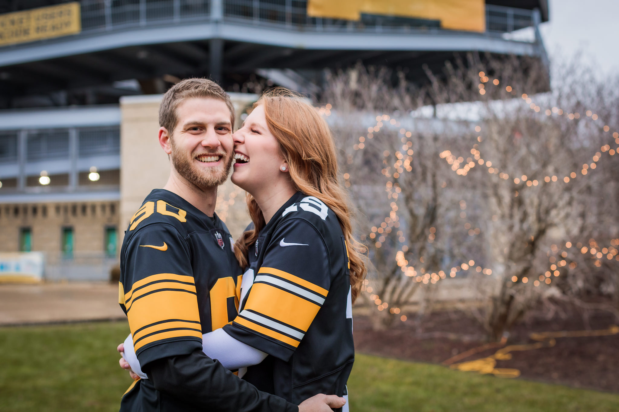Couple laughs during Steelers engagement session at Heinz Field in Pittsburgh, PA