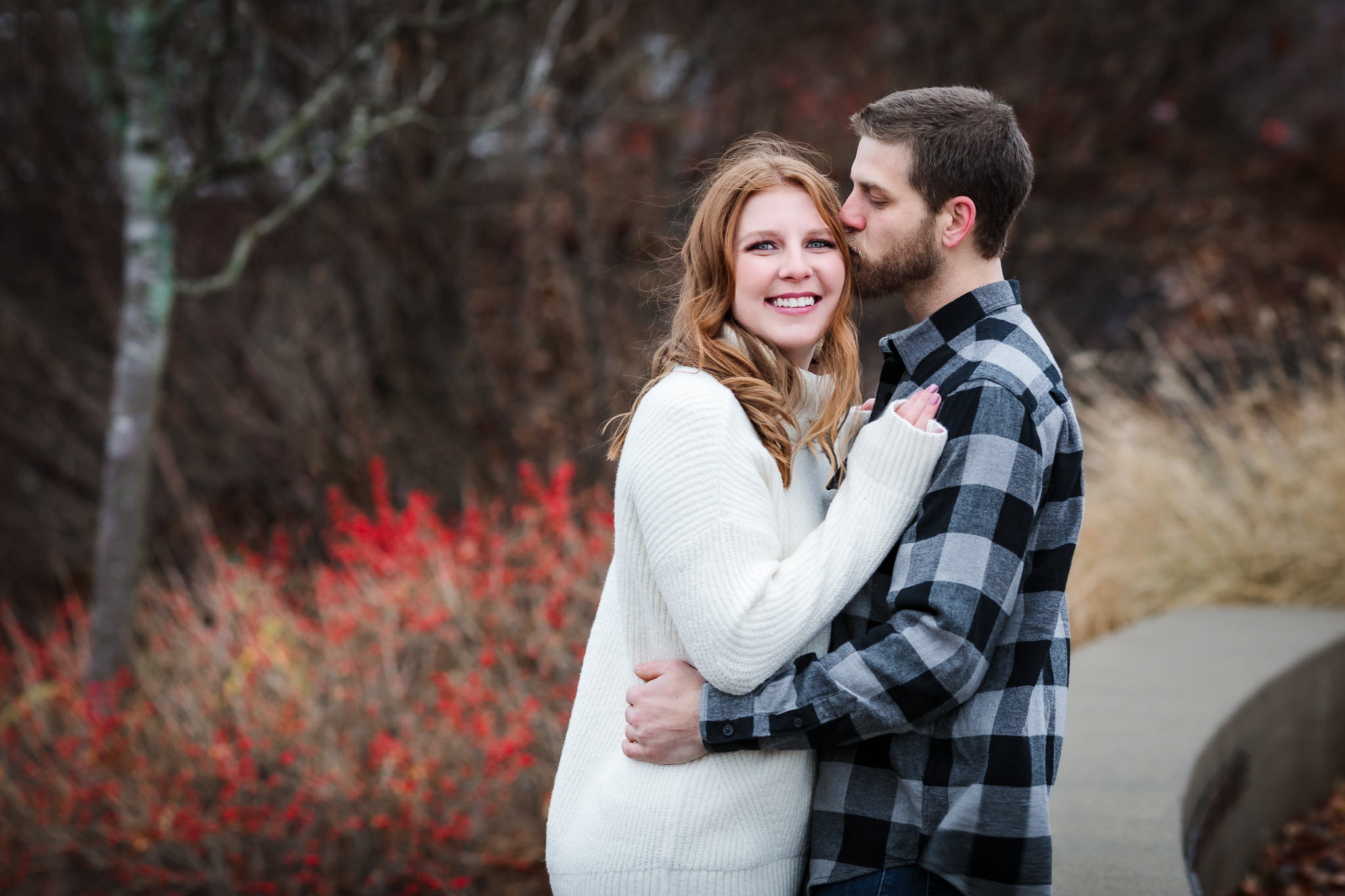 Groom-to-be kisses his fiance's head at a Christmas North Shore engagement session