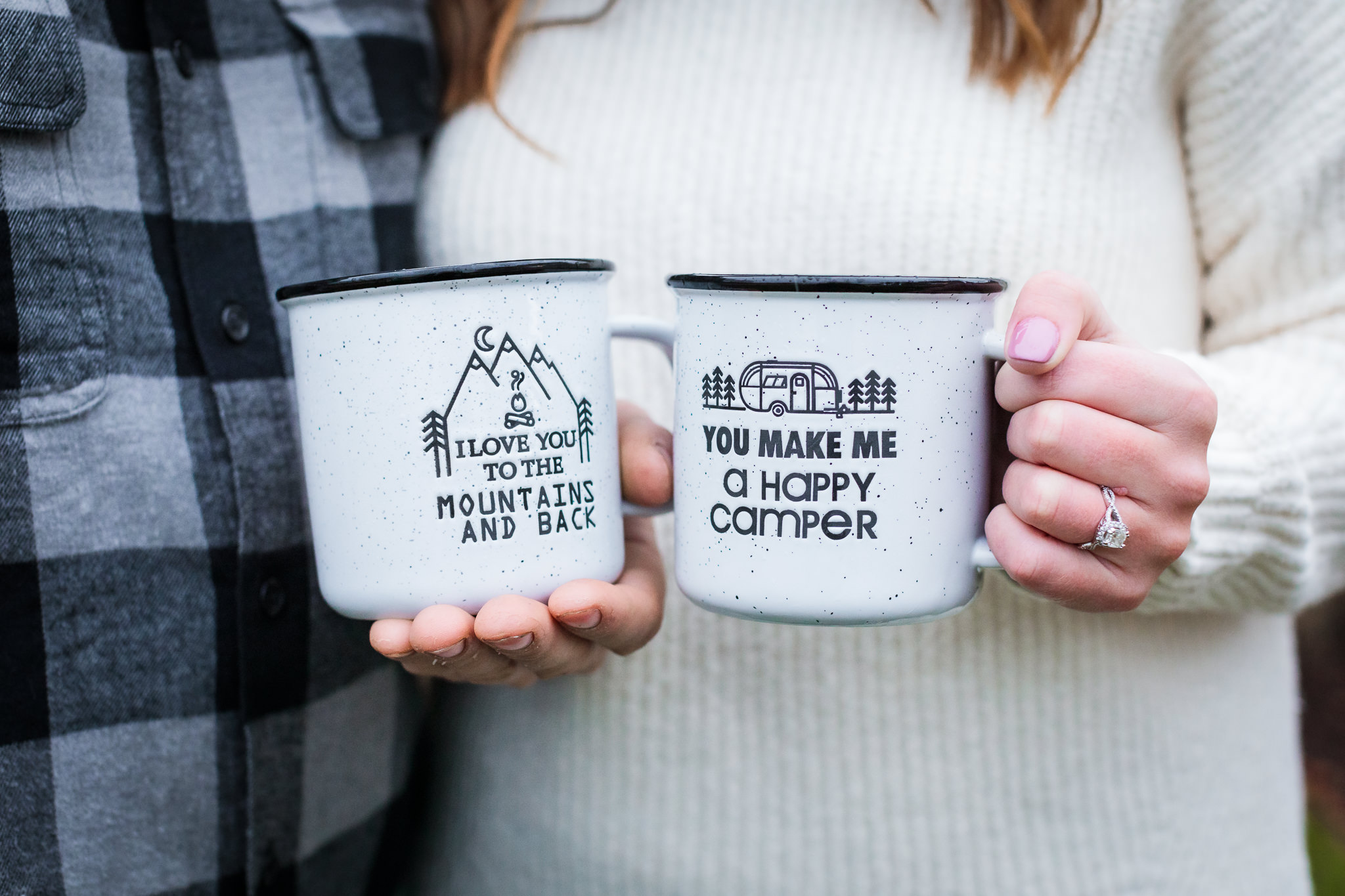 Engaged couple holds mountain mug and camping mug during a North Shore engagement session