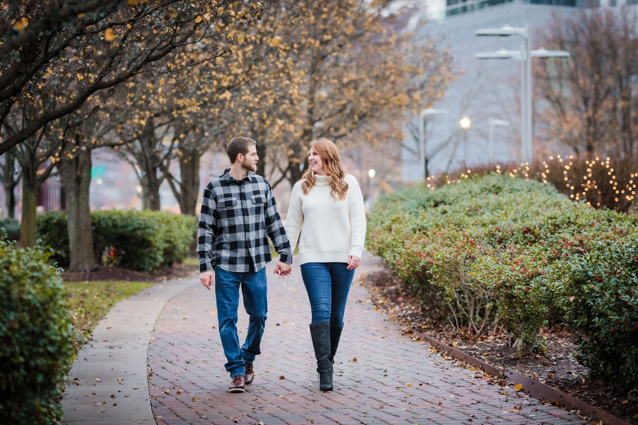 Engaged couple walks down a sidewalk during a North Shore engagement session
